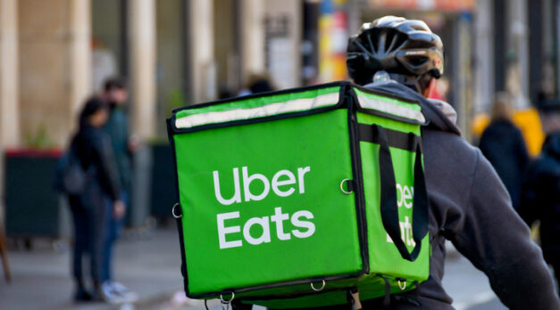 Cardiff, Wales - March 2022: Cycle courier for the Uber Eats food delivery service riding through the city centre