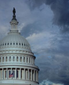Close up of the US capitol building dome with gathering storm clouds. Concept of political and social turmoil coming.