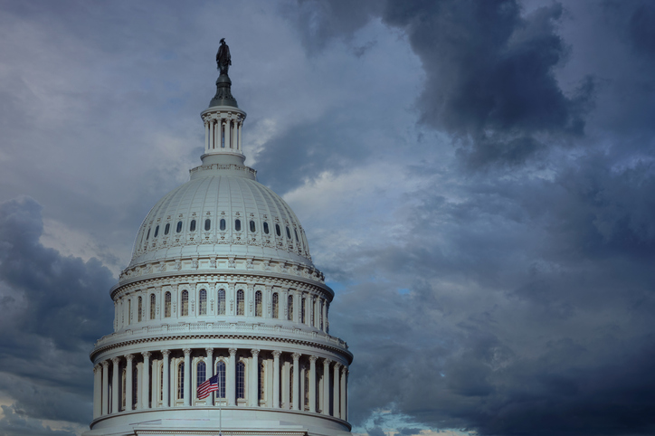 Close up of the US capitol building dome with gathering storm clouds. Concept of political and social turmoil coming.