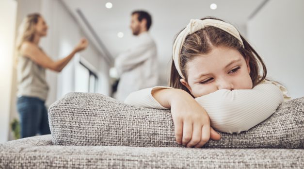 Sad little girl, sofa and parents in conflict, disagreement or fight in the living room at home. Family, divorce and husband in argument with wife and unhappy child on lounge couch in depression